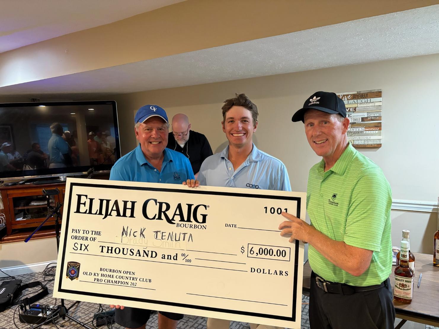 Nick Tenuta holding the championship check with two guys on the sides of him