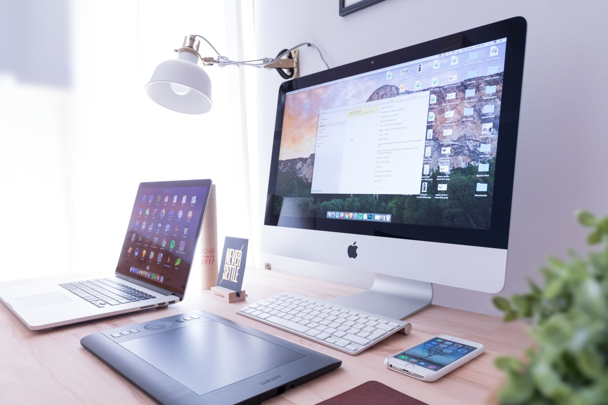 Laptop and Mac desktop on wooden desk