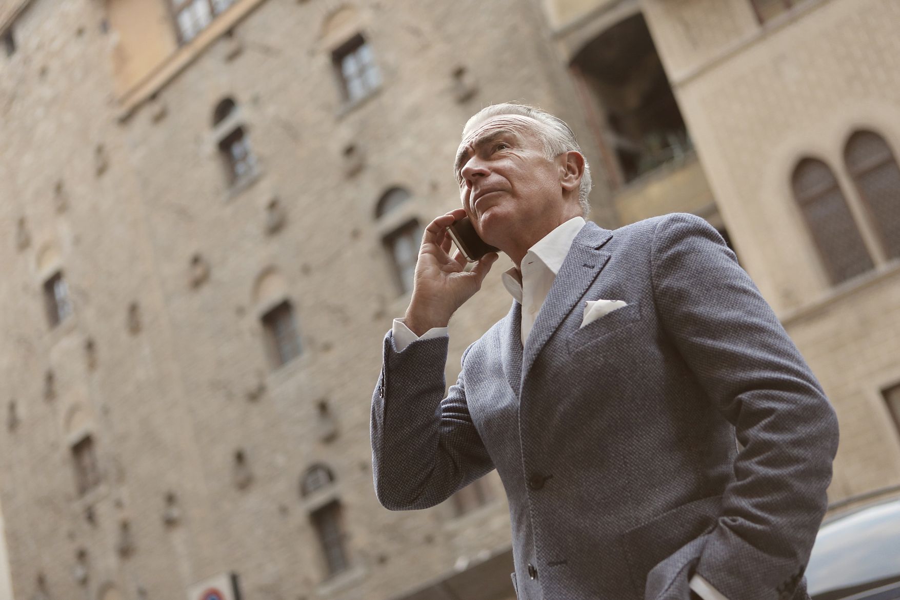 Man in grey suit talking on phone