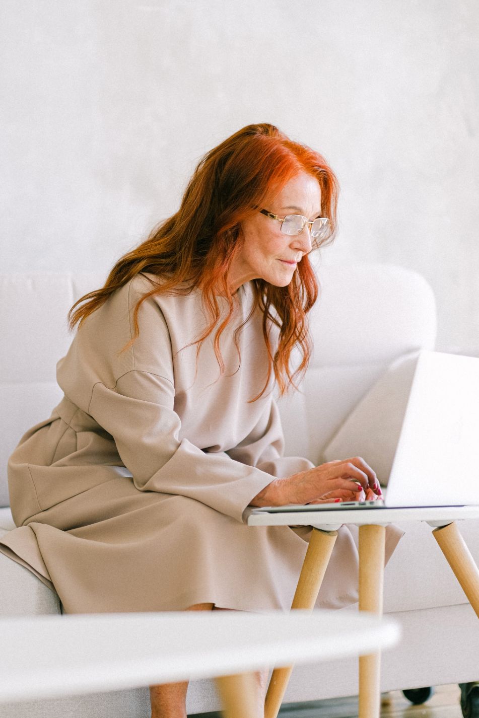 Woman working on computer sitting on a couch