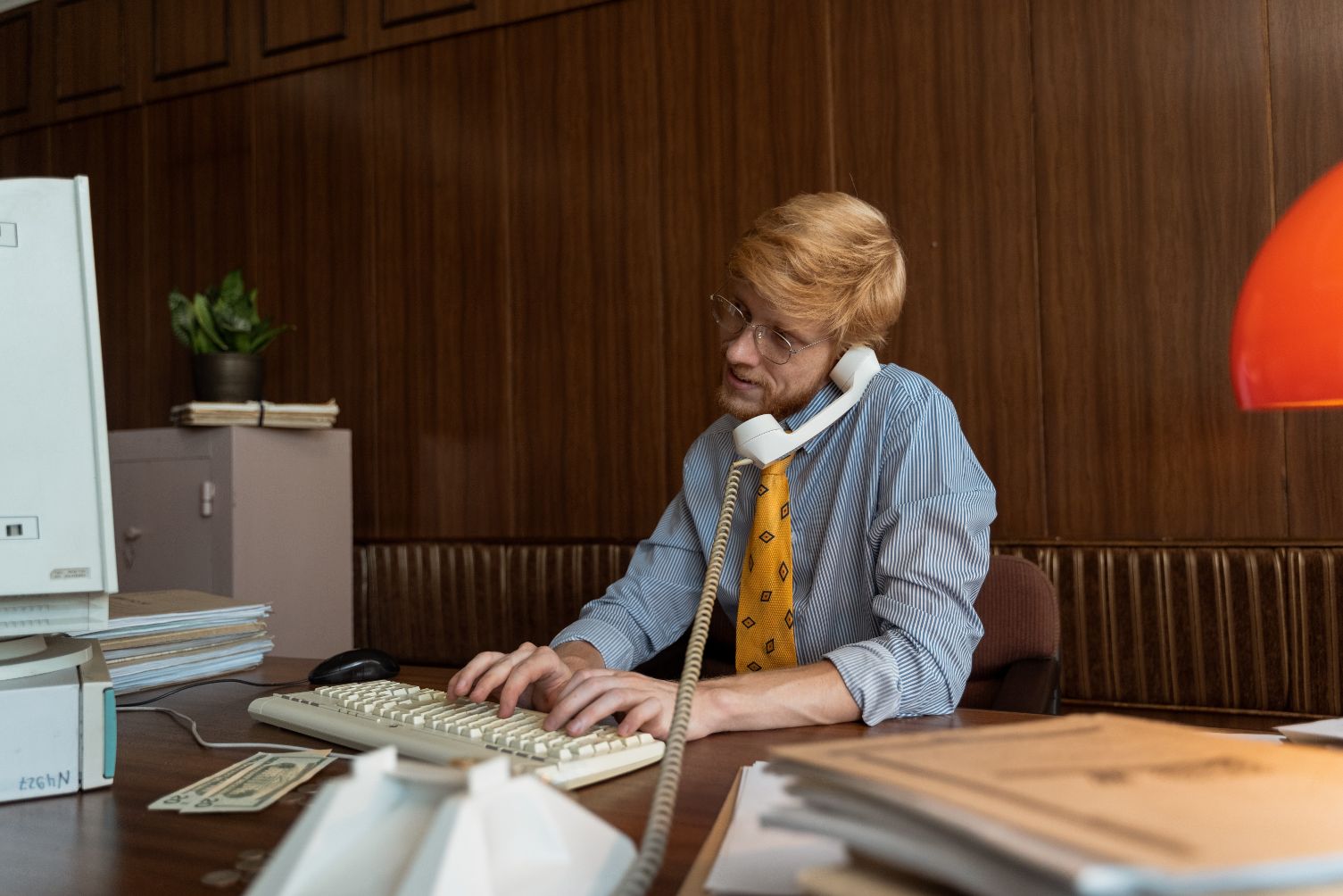Man talking on phone and working on computer