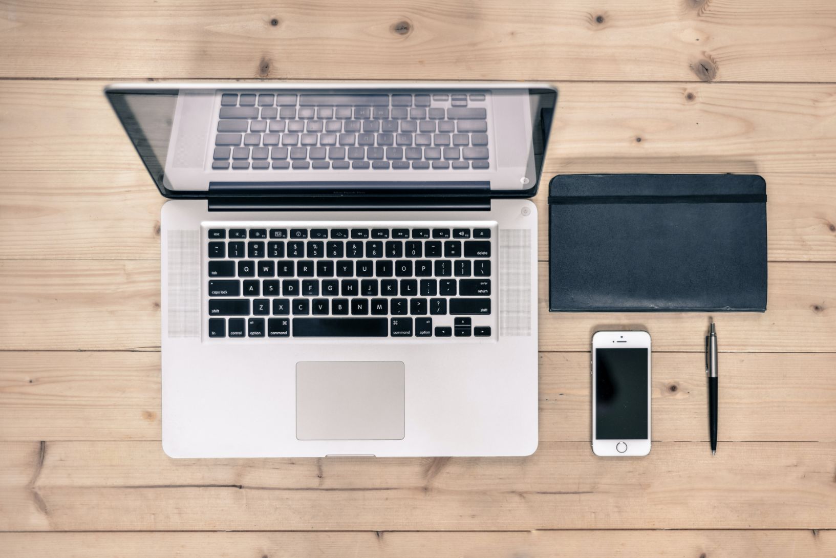 Laptop open next to a phone and tablet