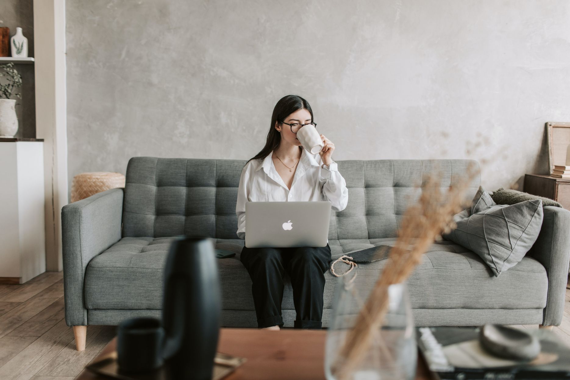 Person drinking coffee while working on a laptop