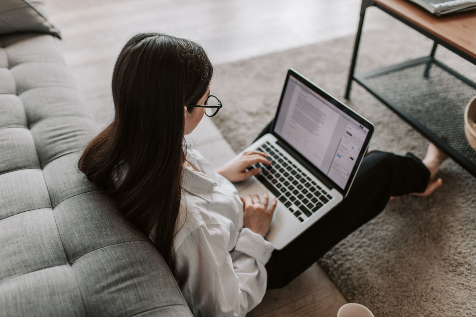 Woman sitting on the floor working on laptop