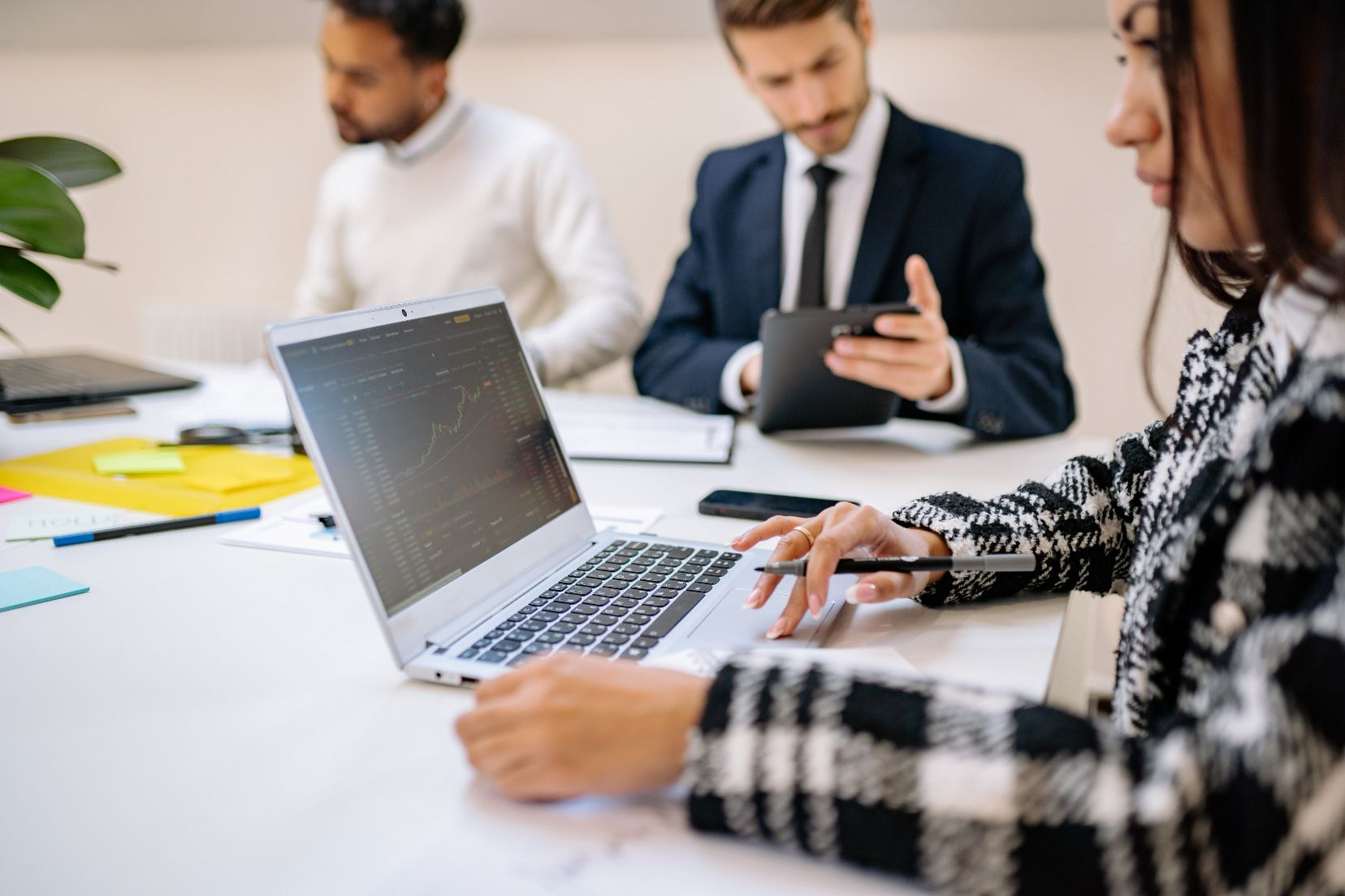 People working on devices in a conference room setting