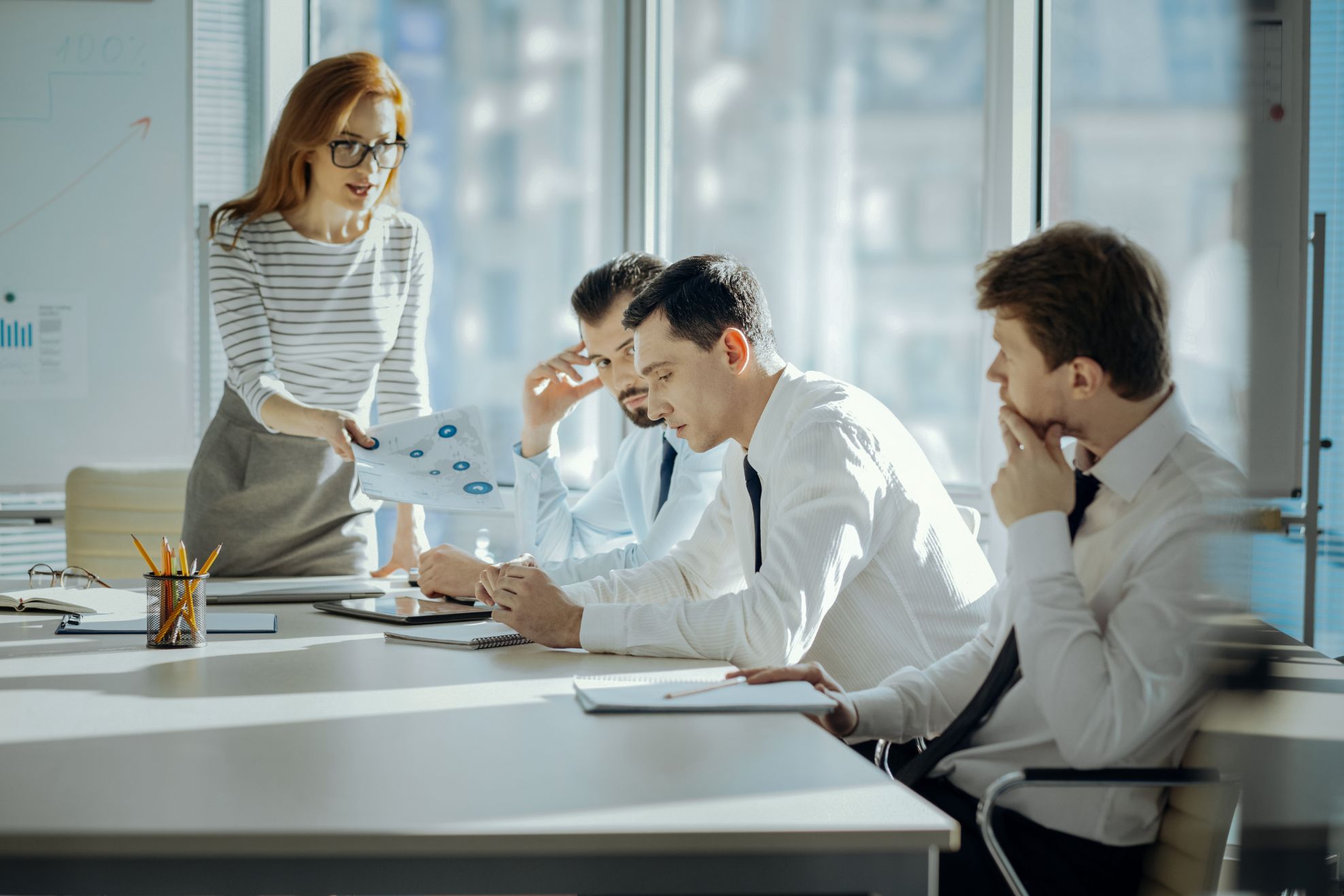 Business people in a meeting room talking at a desk 