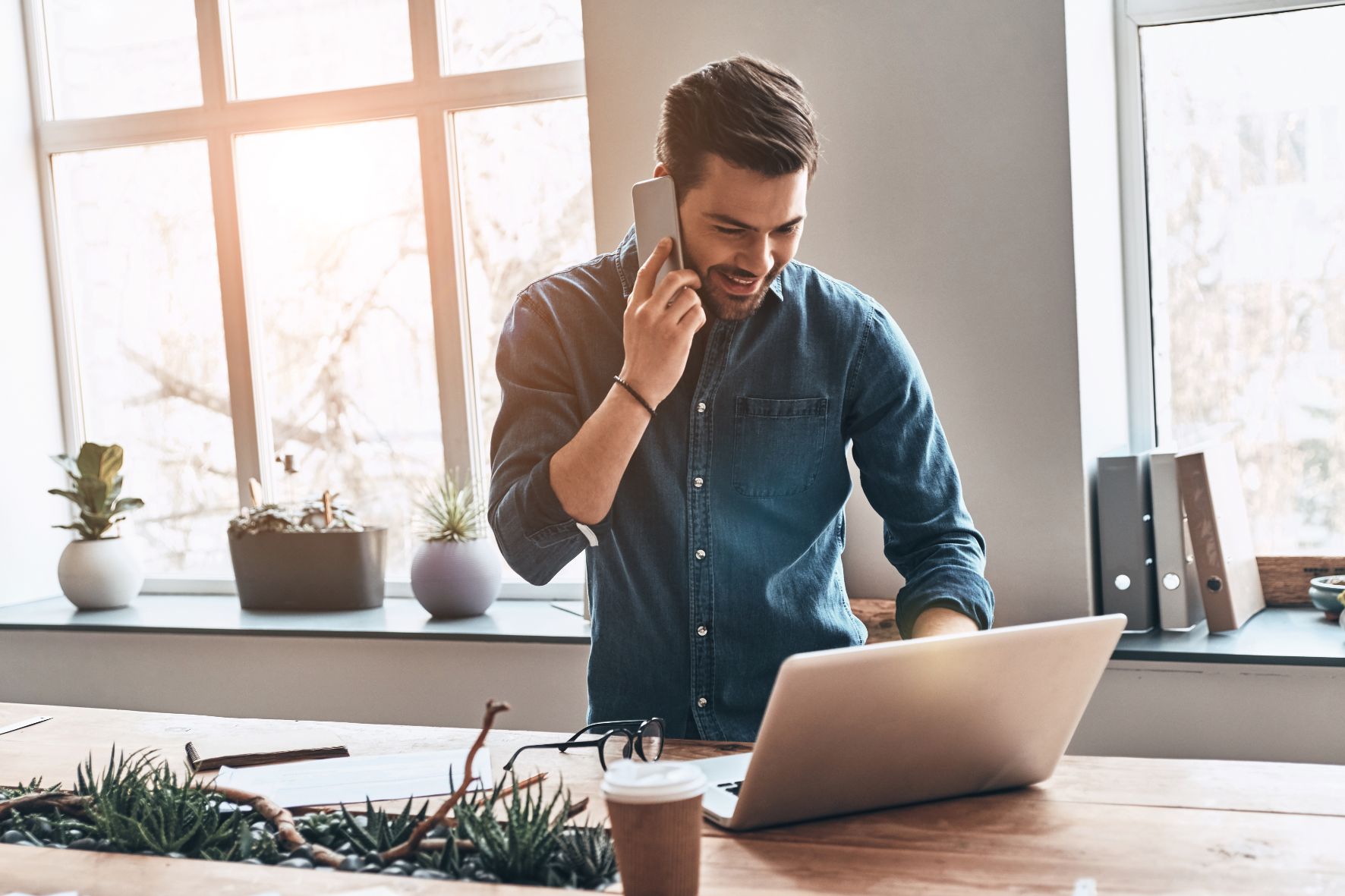 Business man talking on phone and working on laptop