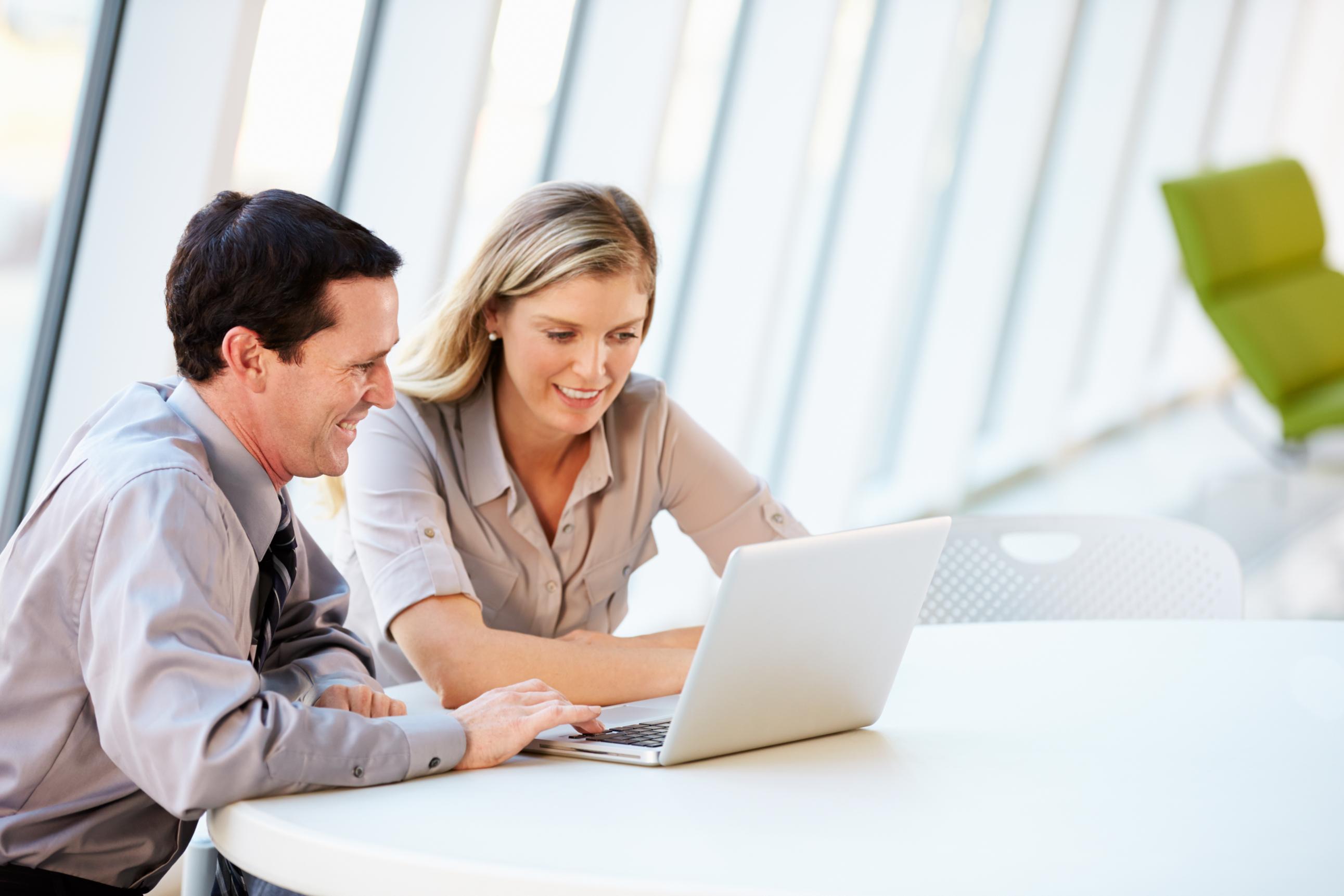 Two business people working on a computer together at a table