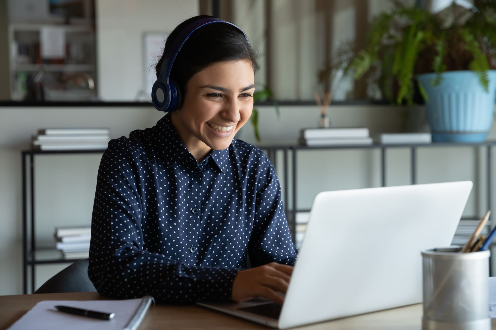 Business woman working on laptop with a headset on