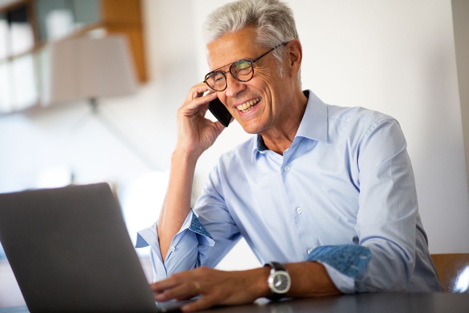 Business man talking on the phone while looking at computer