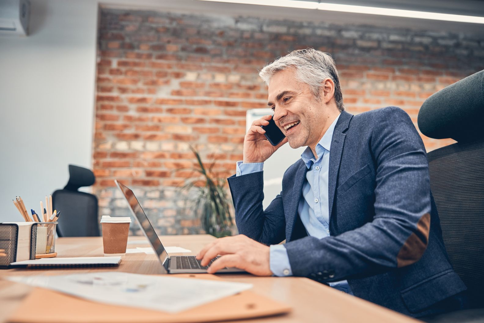 Business man working in office on the phone working on computer