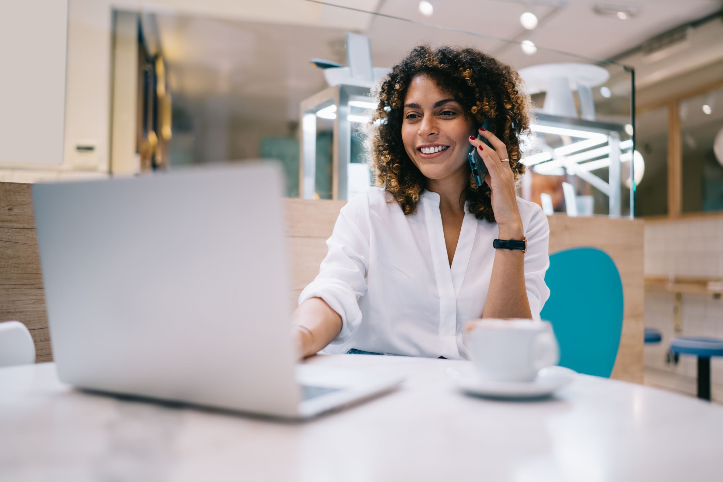 Business woman talking on phone while working on computer