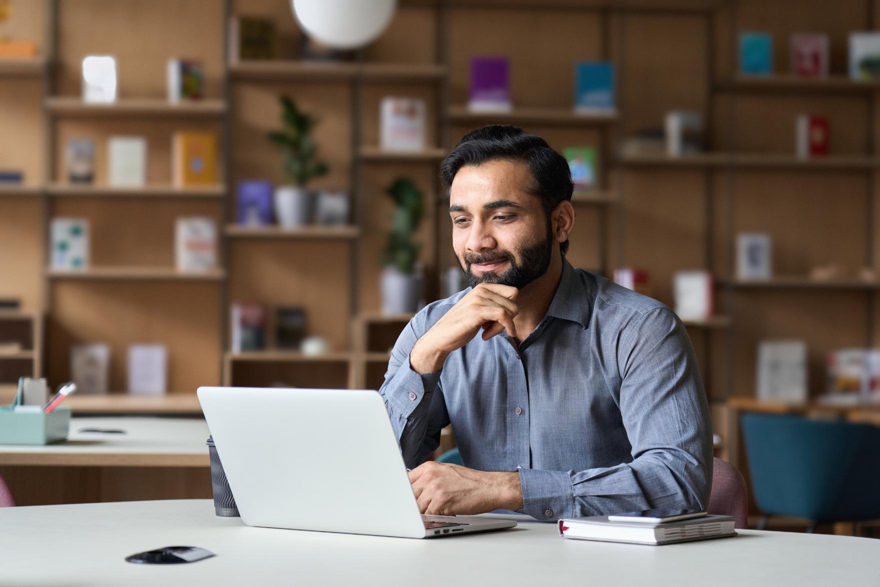 Business man working on laptop at a table in home office