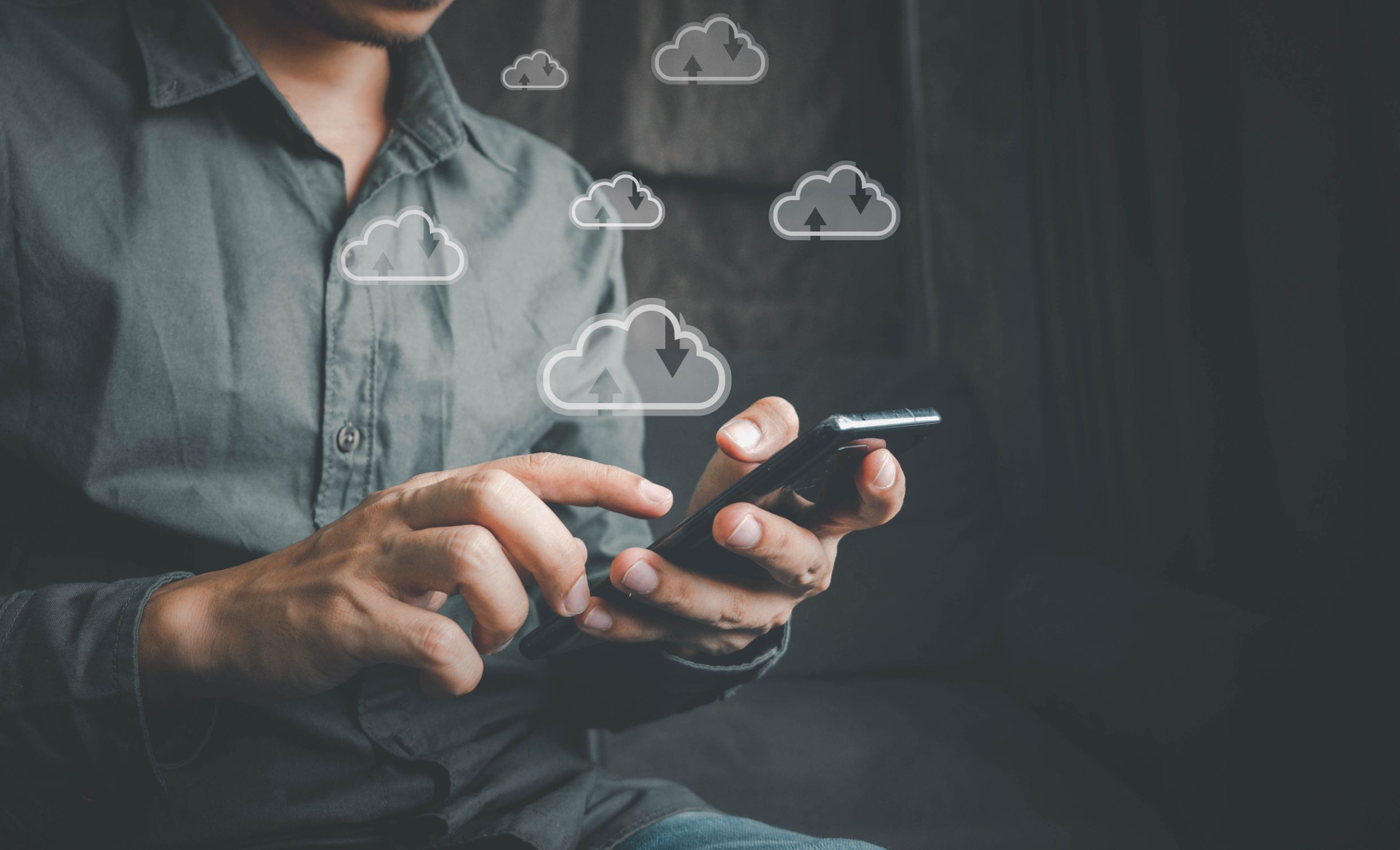 Man working on phone with cloud technology