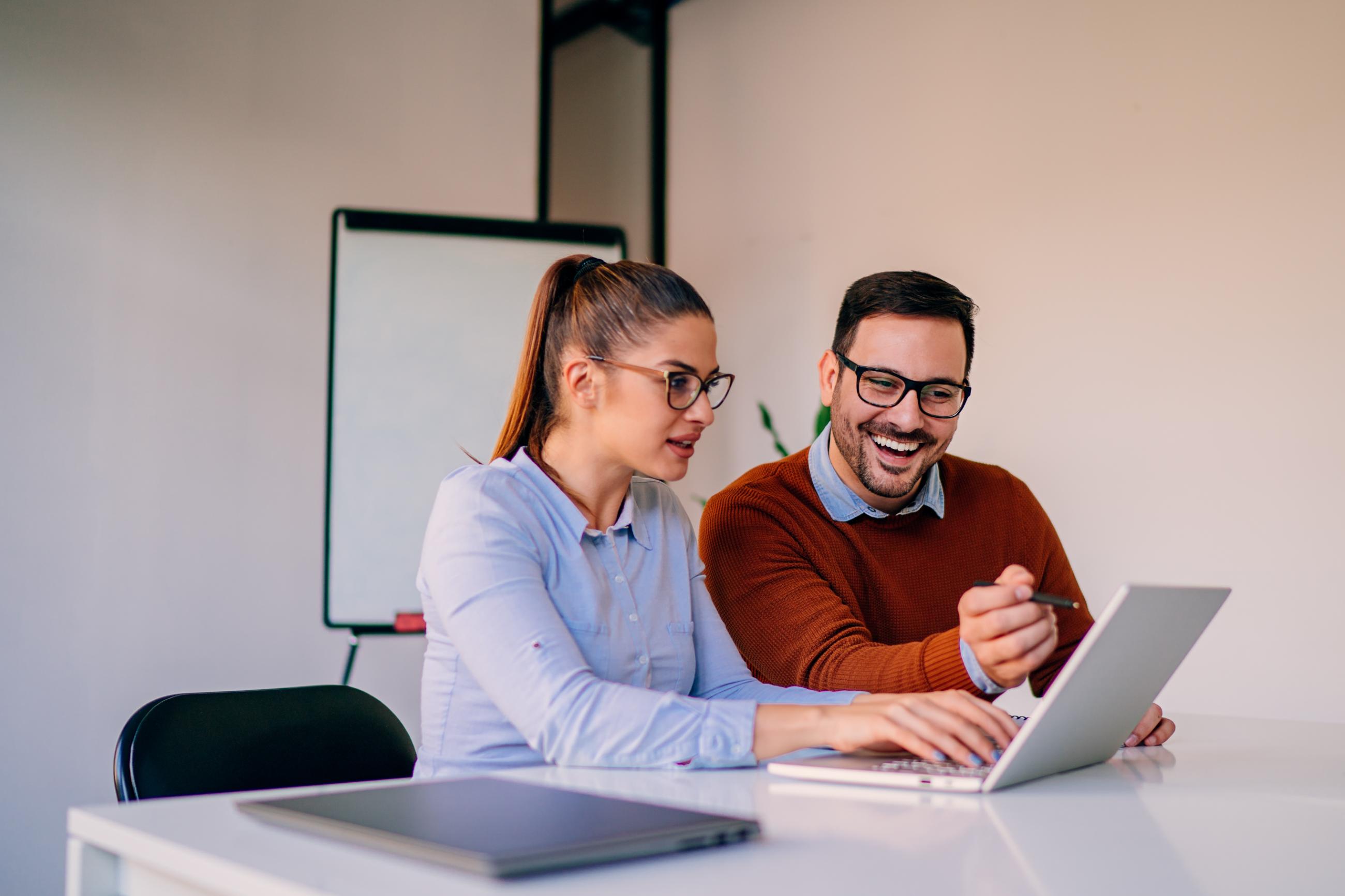 Two business people working on a laptop at a desk