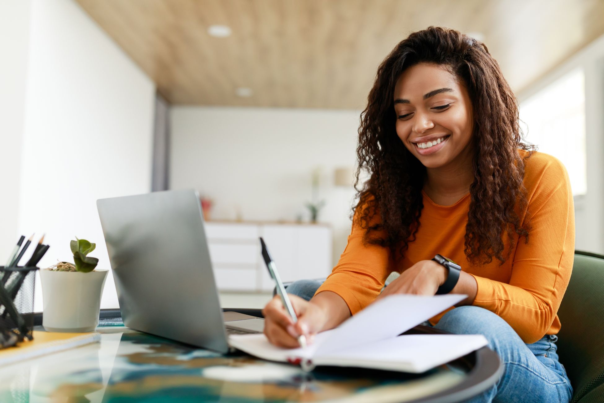 Business woman working on computer and taking notes