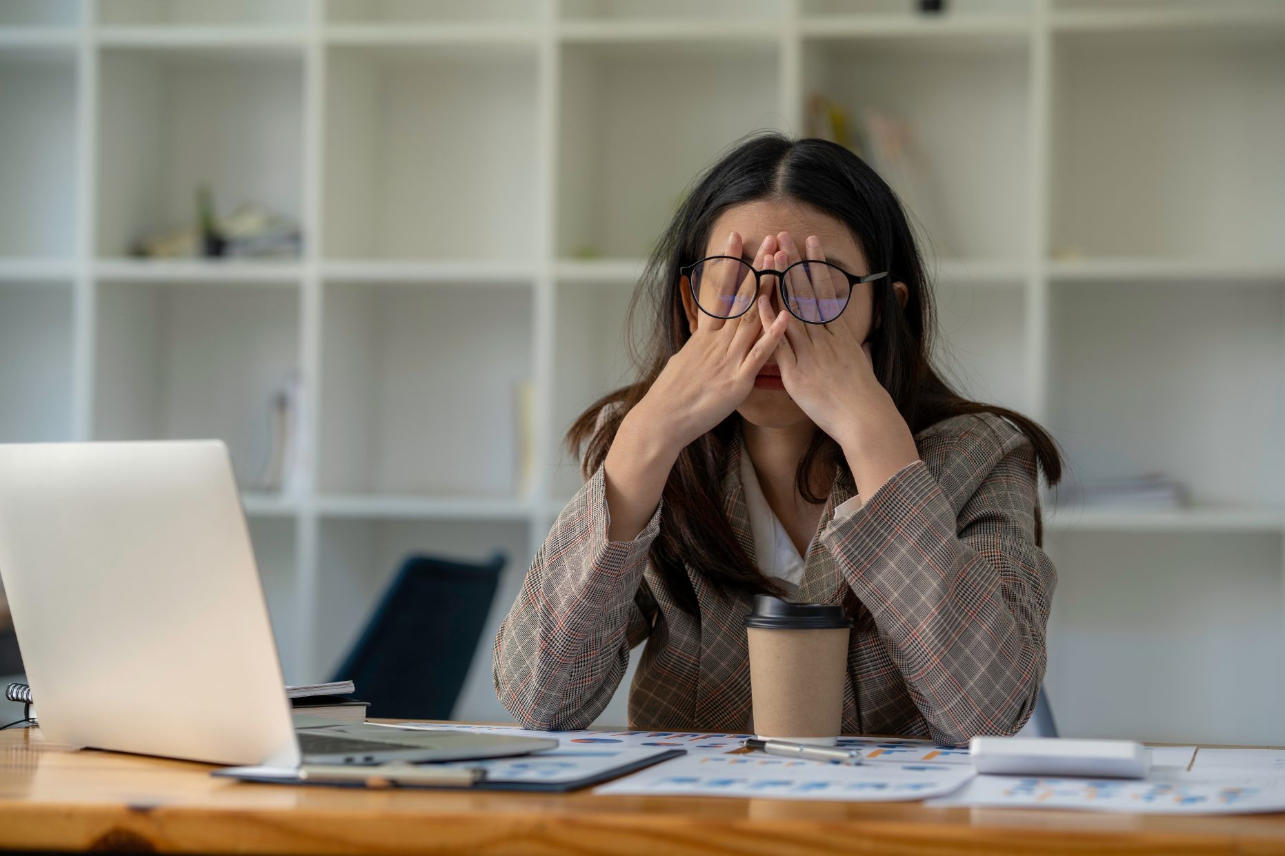 Business woman working at desk upset with hand over her eyes