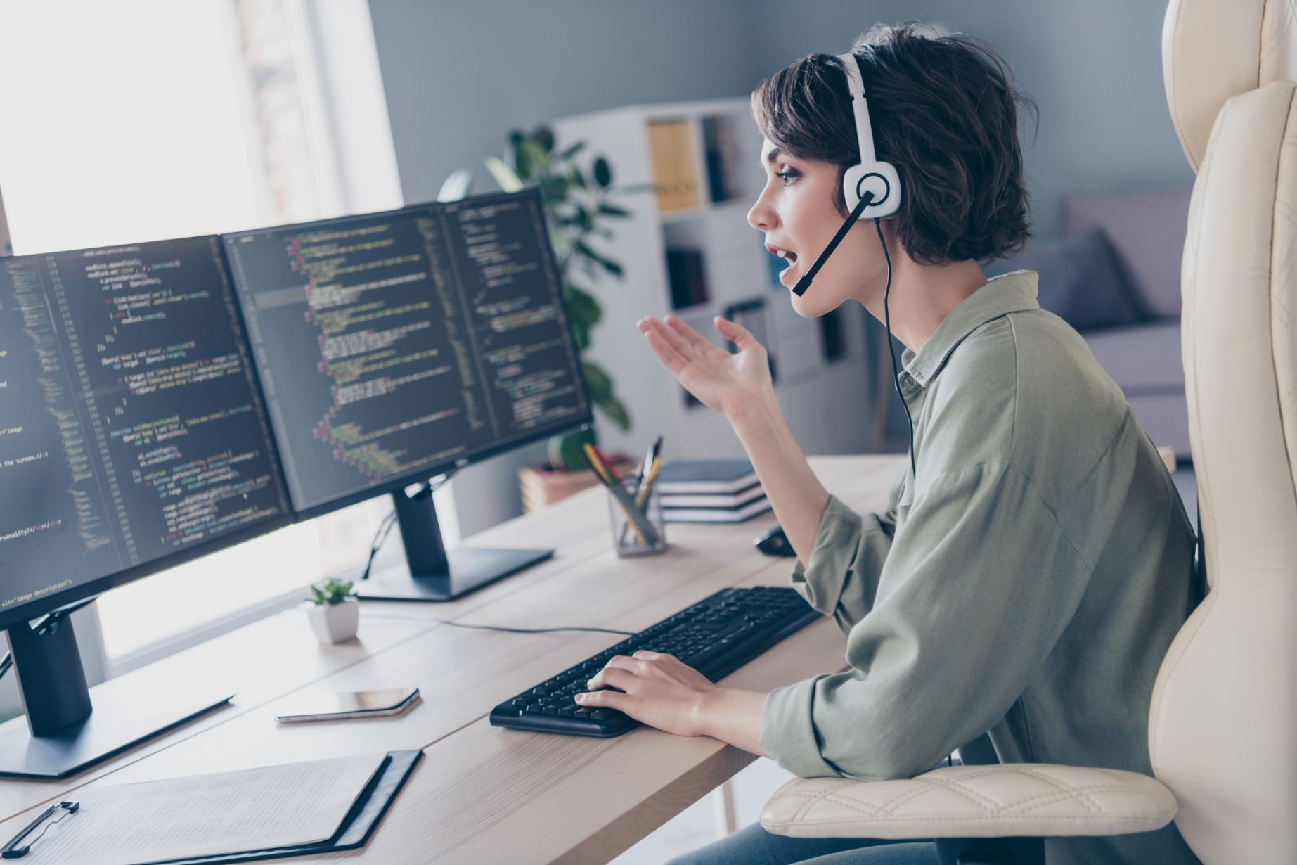 Business woman talking on headset while looking at computer screen