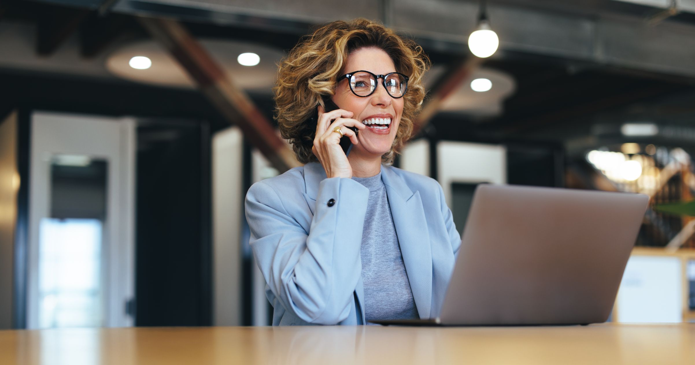 Business woman talking on phone working on a laptop