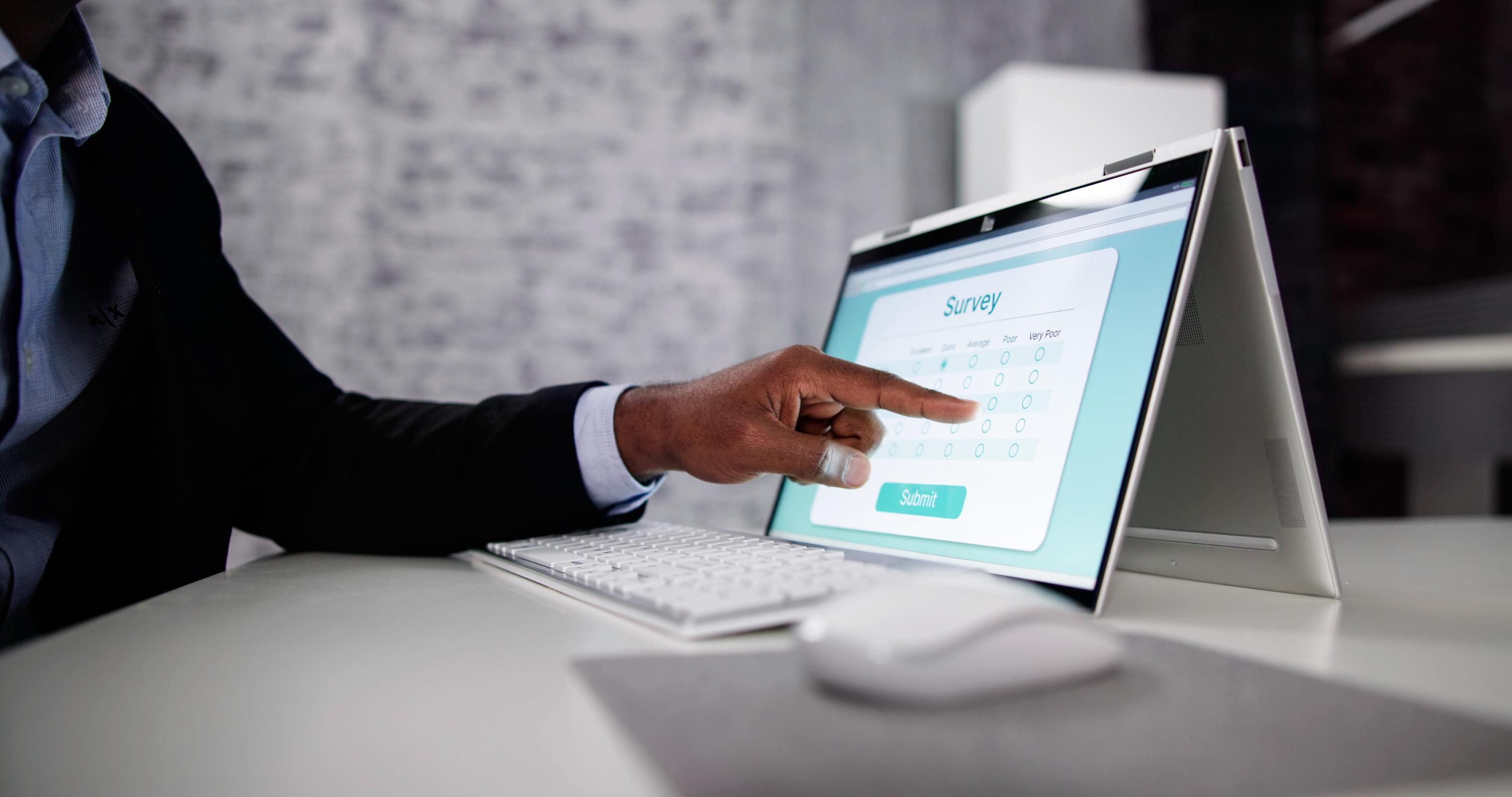 Business man pointing to a computer screen showing a survey