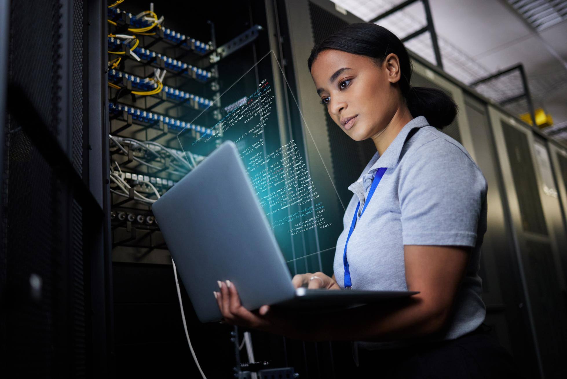 Business woman working in data center on a laptop
