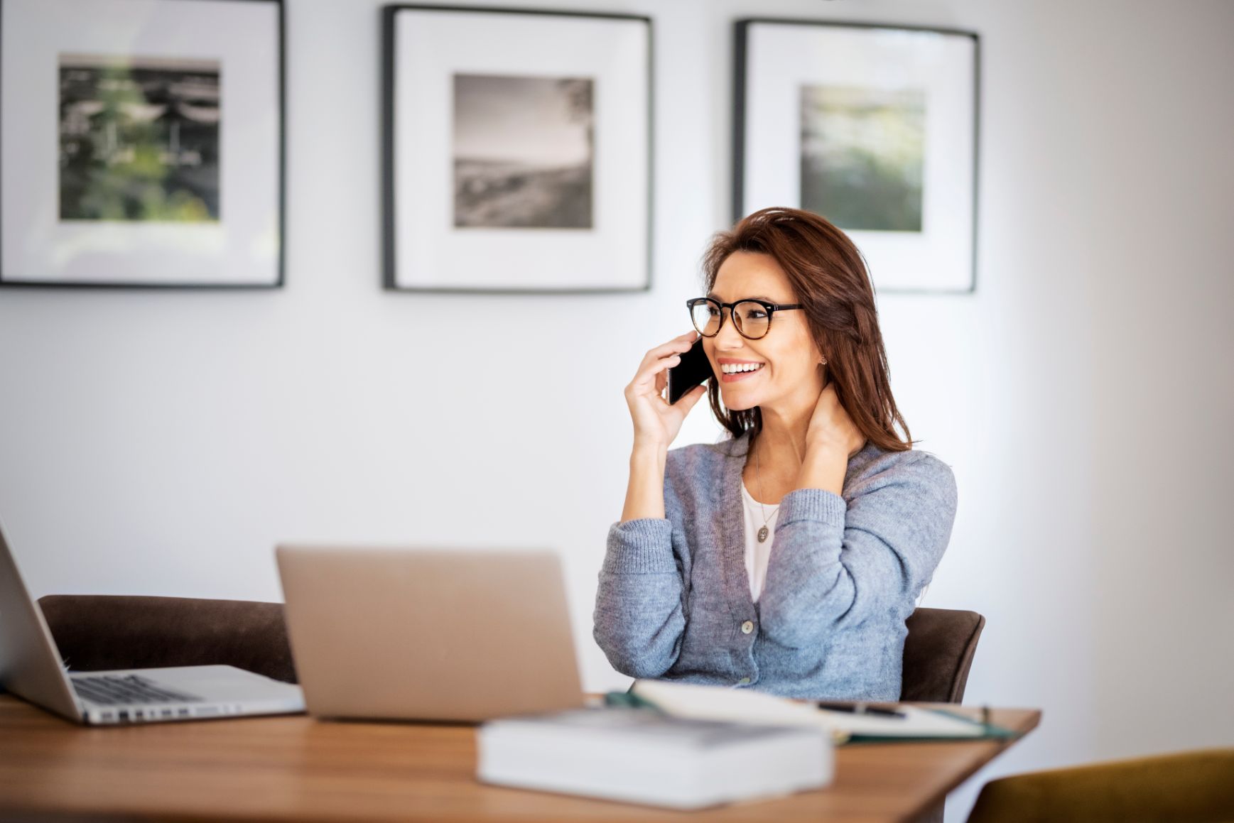 Business woman talking on the phone while working at a desk 