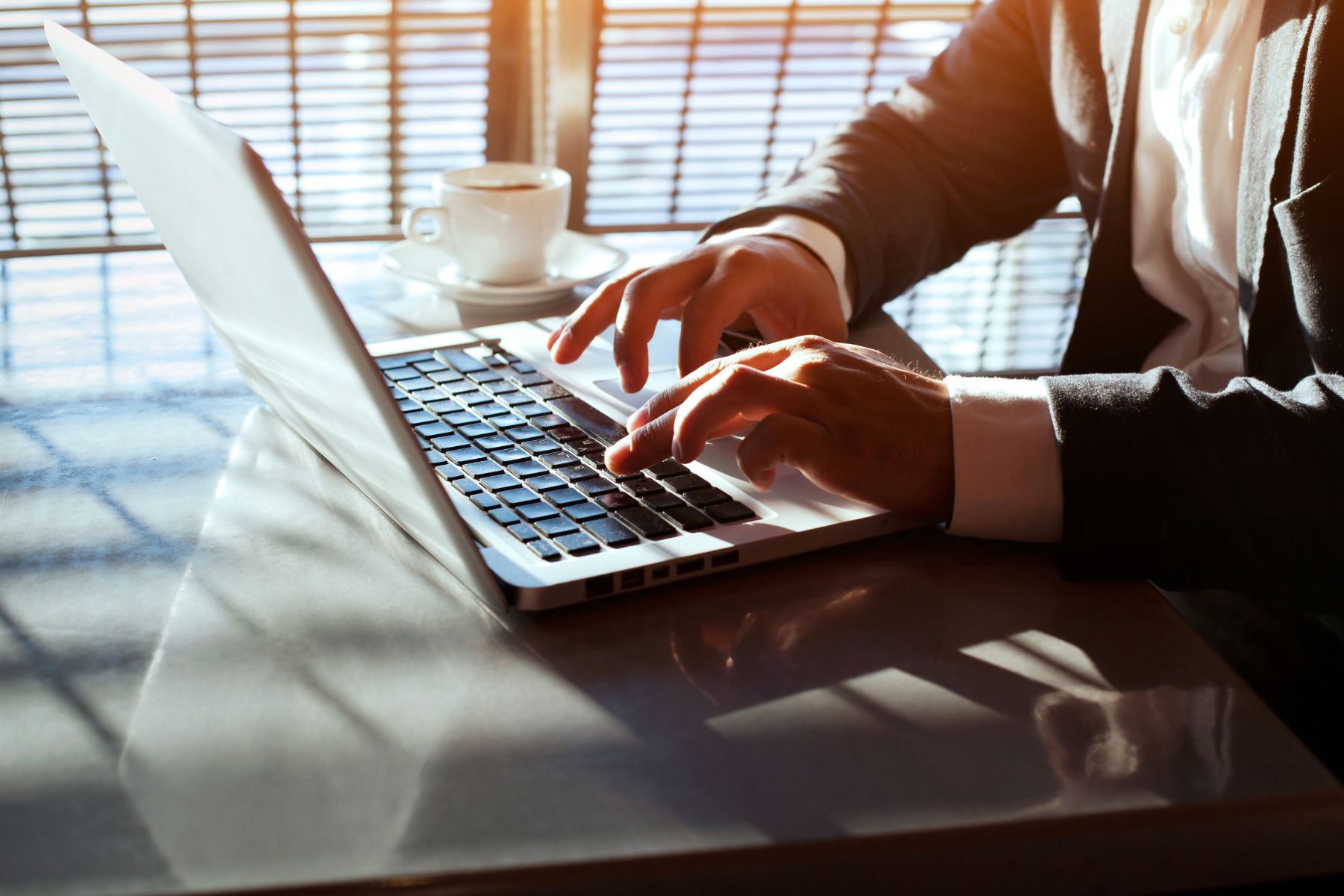 Hands typing on a laptop keyboard