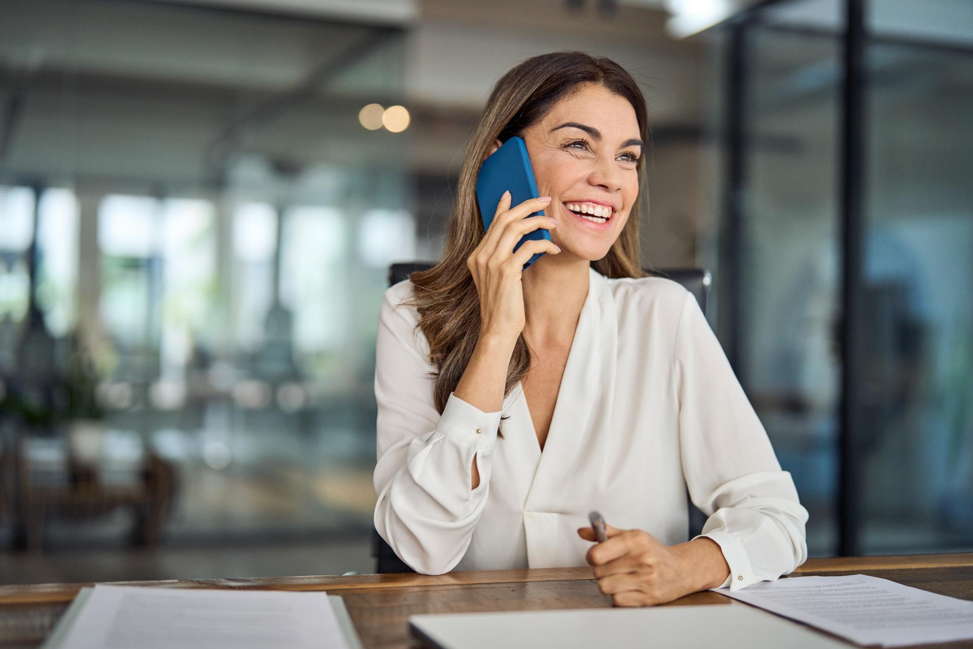 Business woman talking on the phone while sitting at a desk
