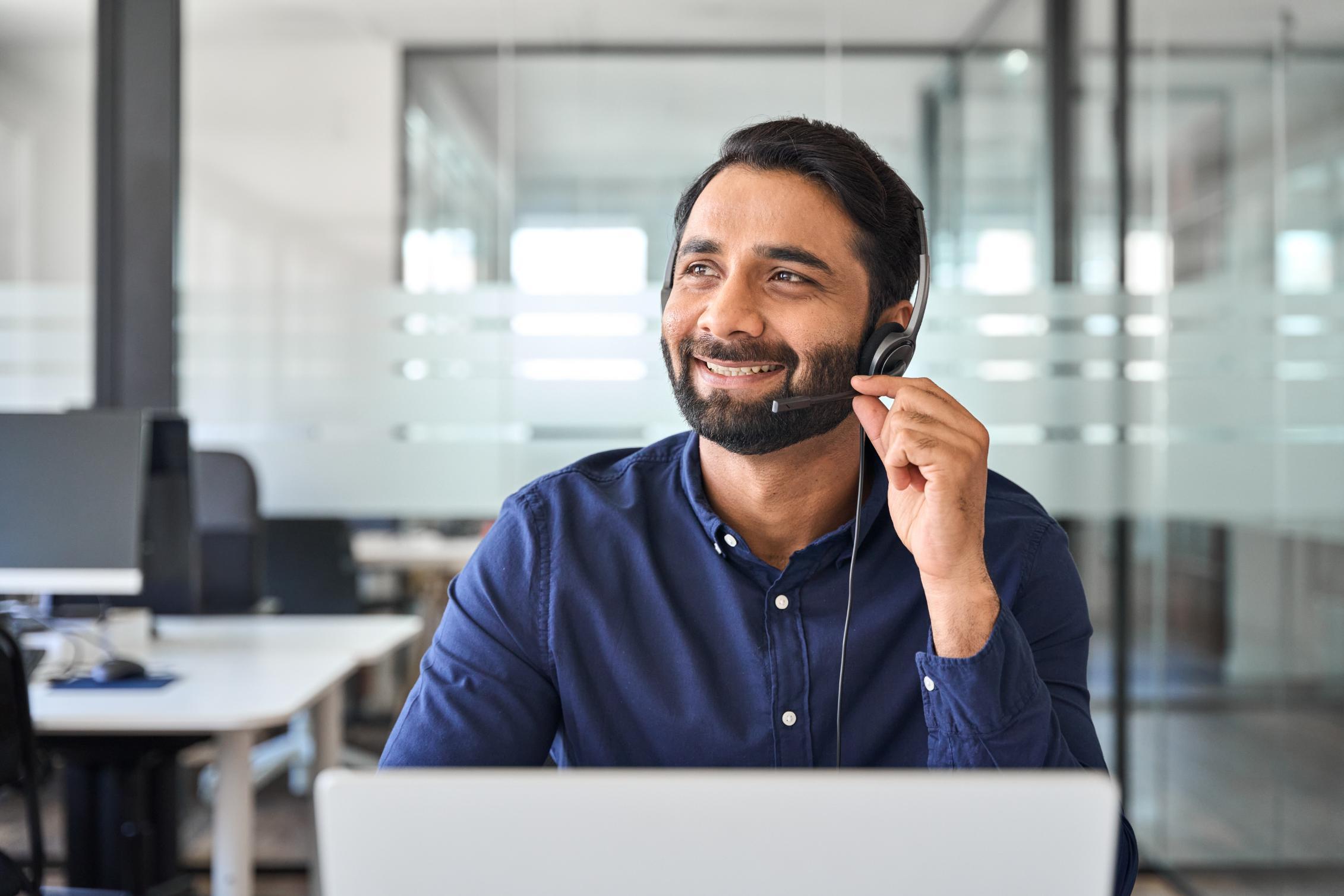 Business man working at a desk talking on a headset