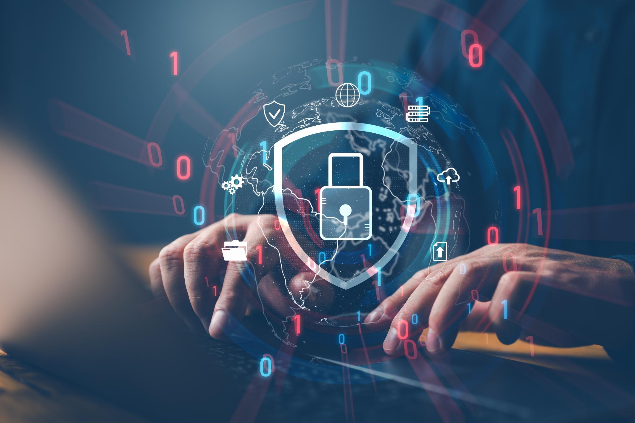 Person typing on a computer with a security graphic over it