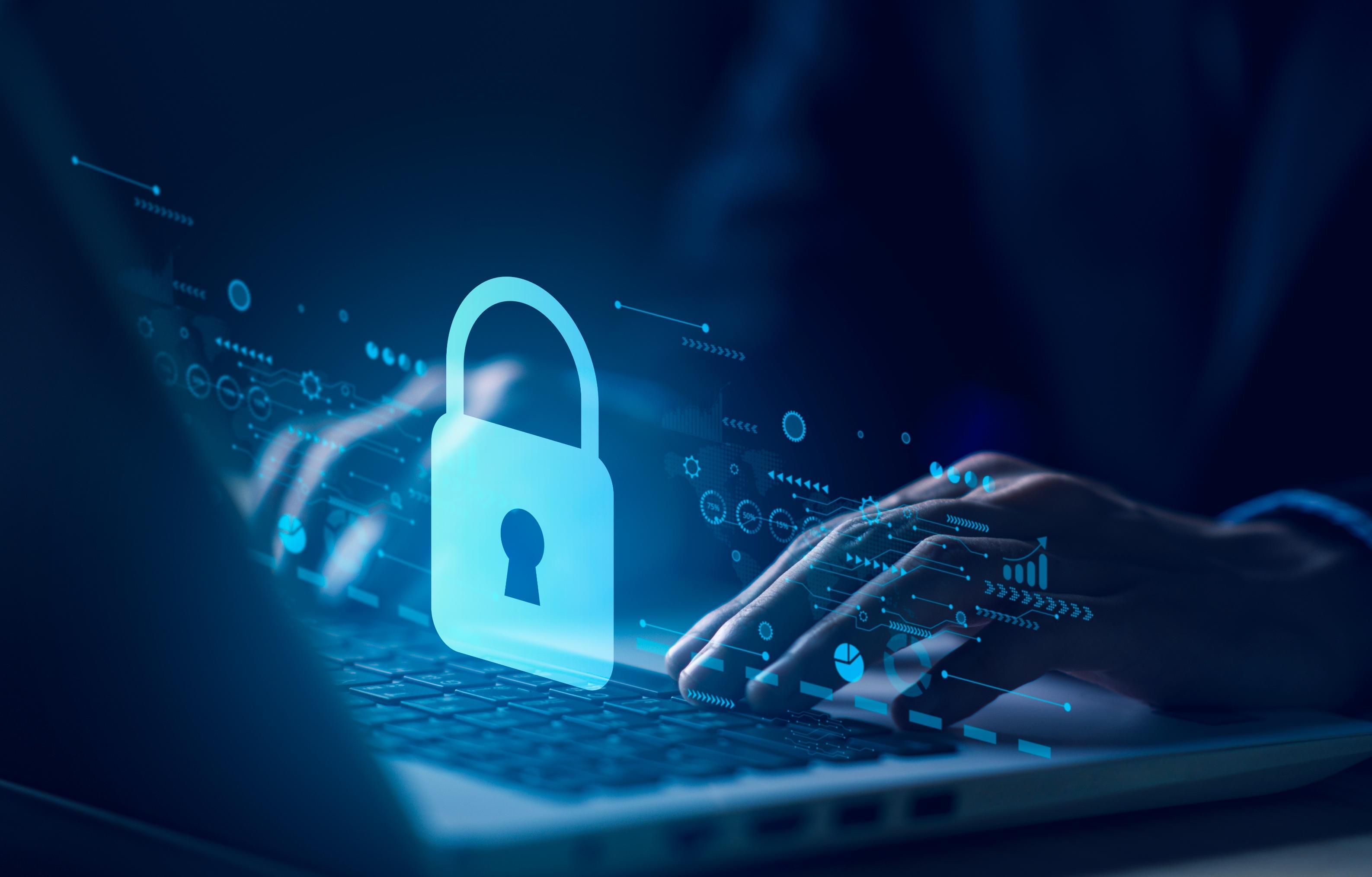 Person typing on a computer with security graphic over the image