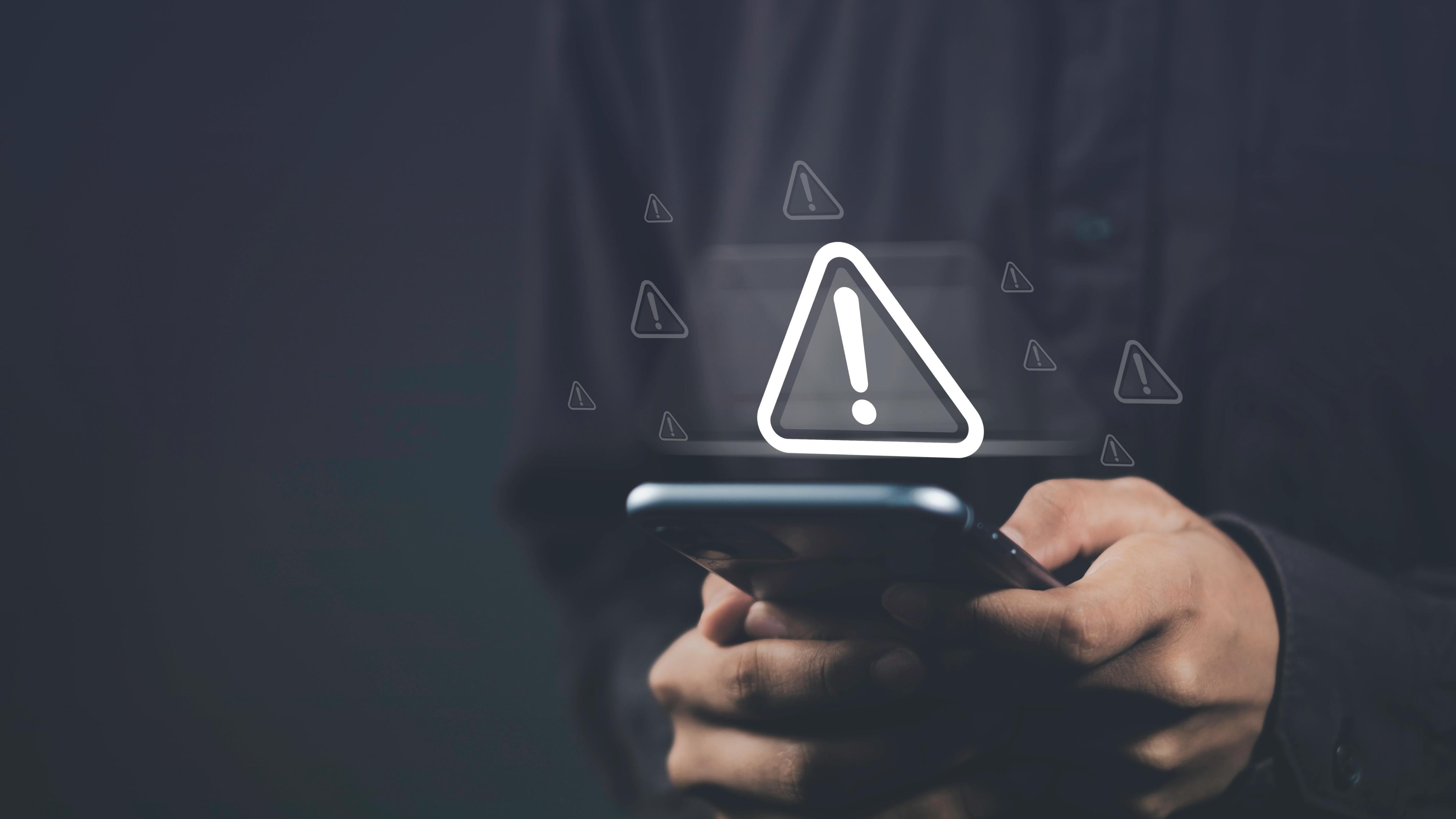 Person holding a phone with a hazard image on it.