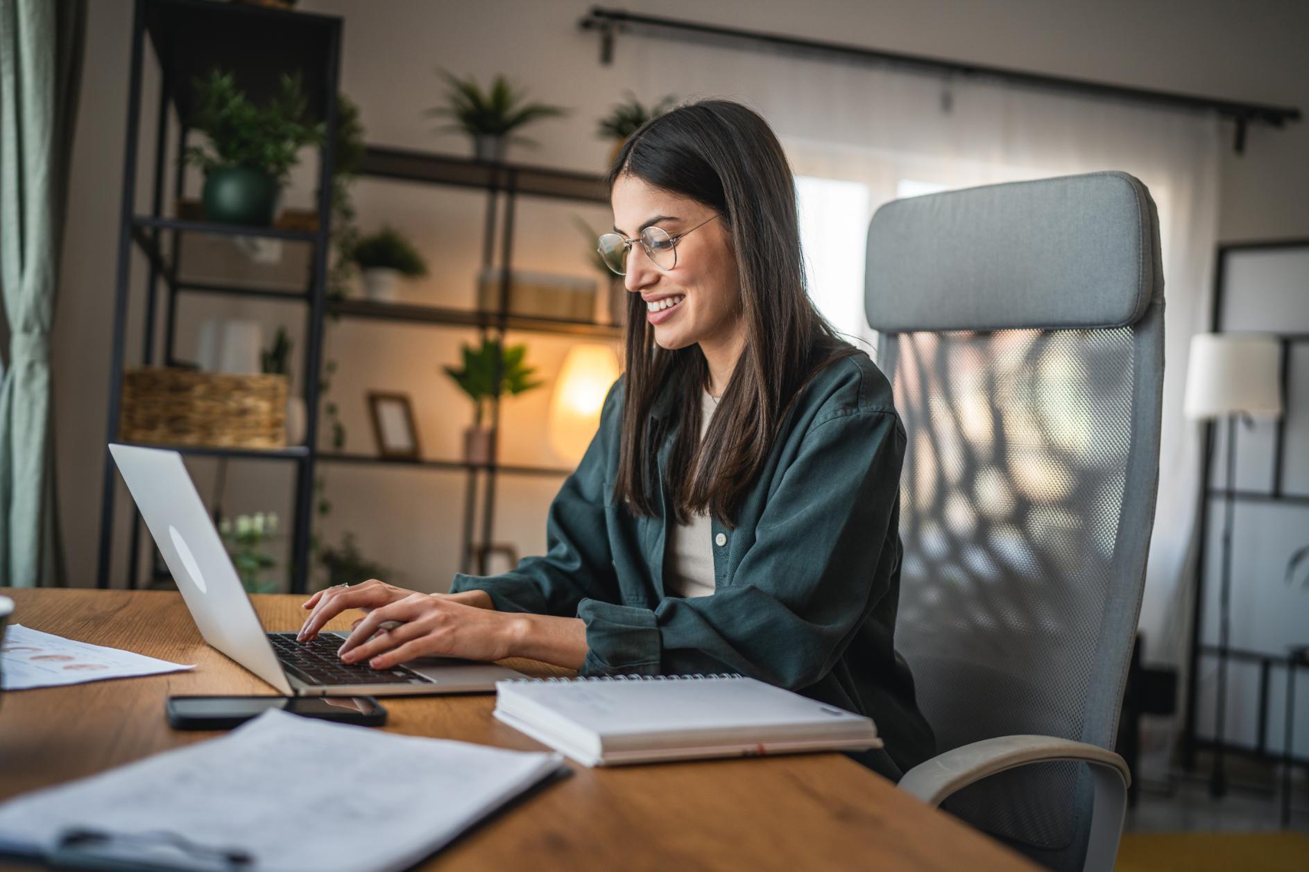 Business woman working on a laptop in her home office at a desk