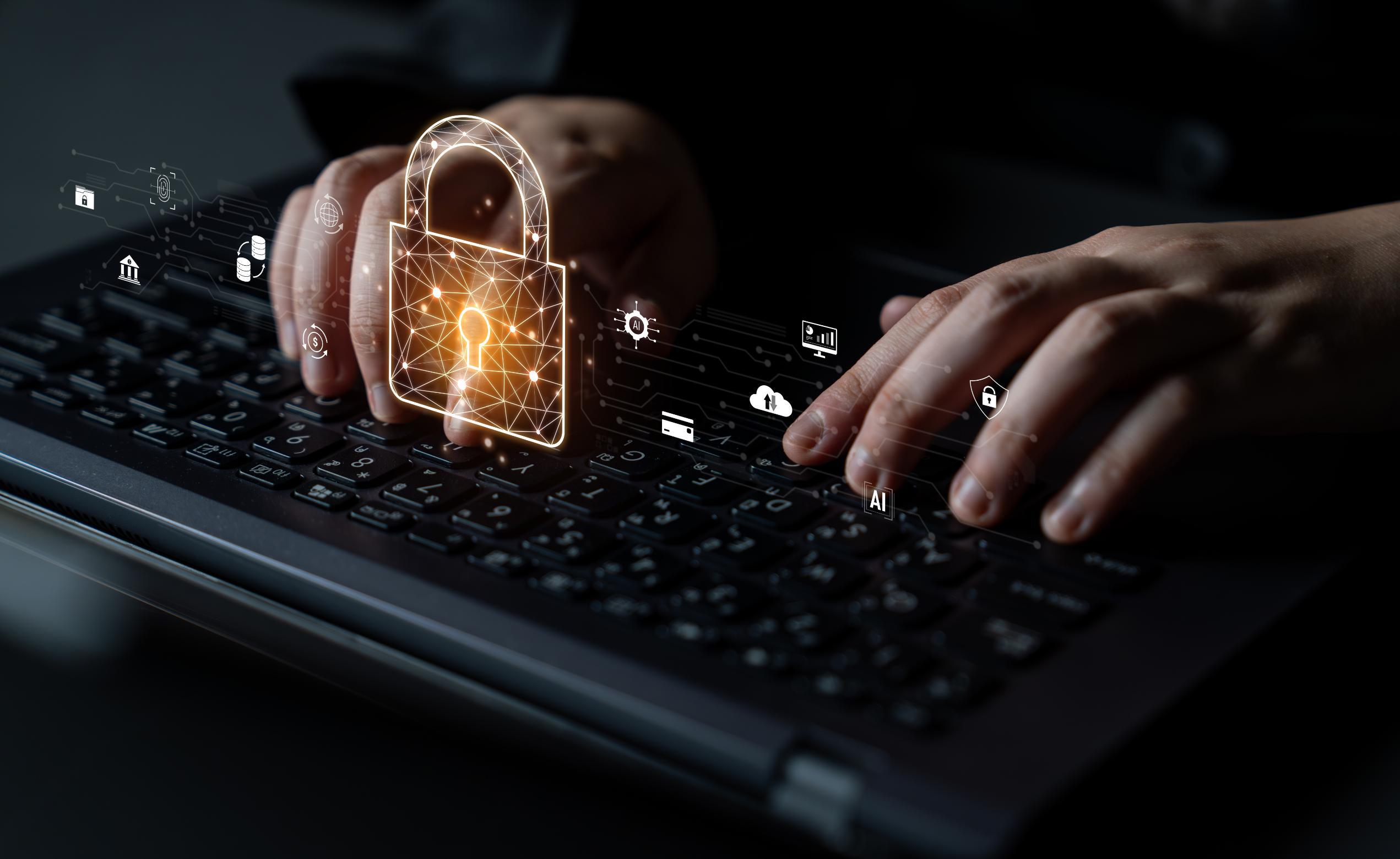 Persons hands on computer keyboard with security graphic over the image