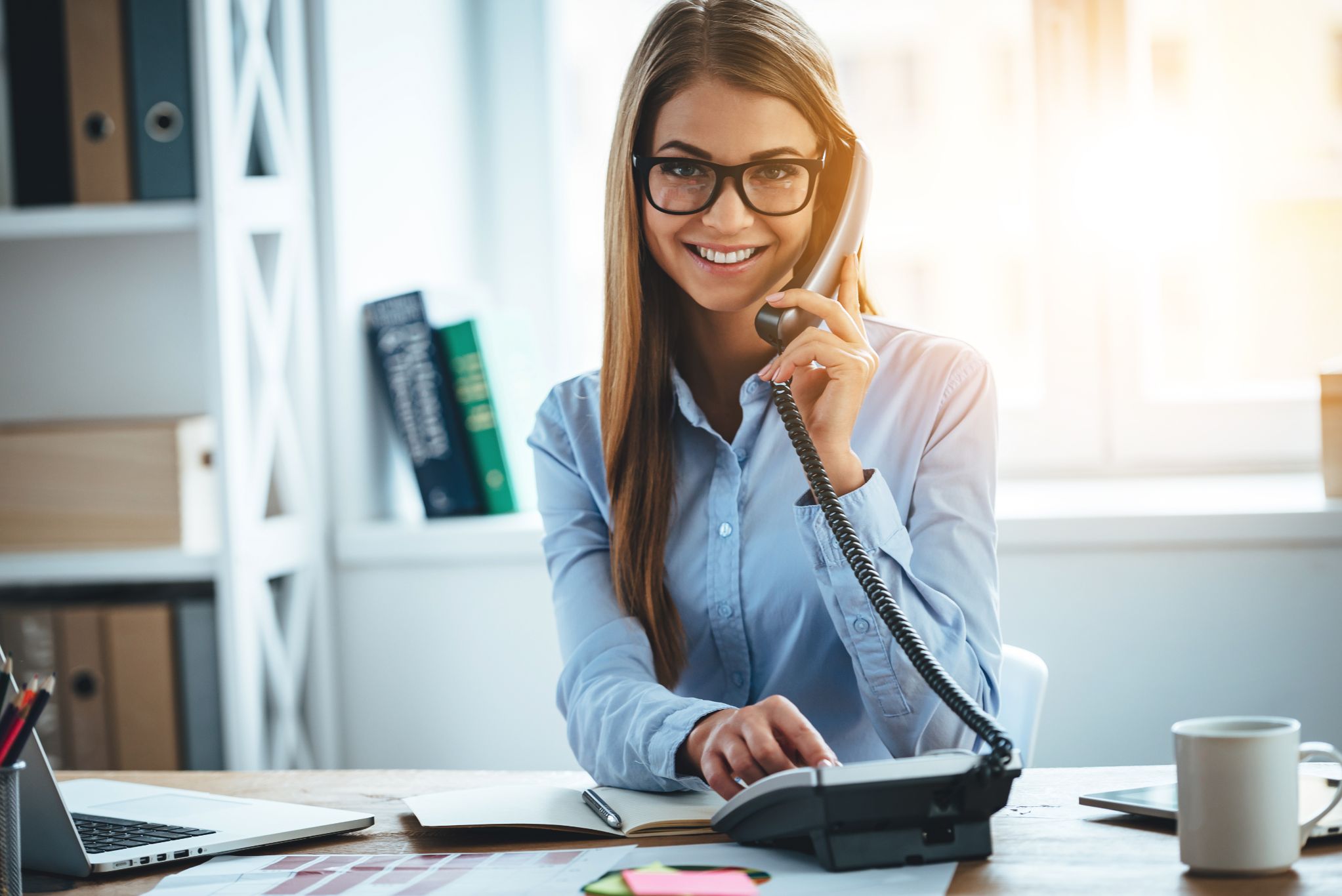 Business woman talking on the phone at a desk 