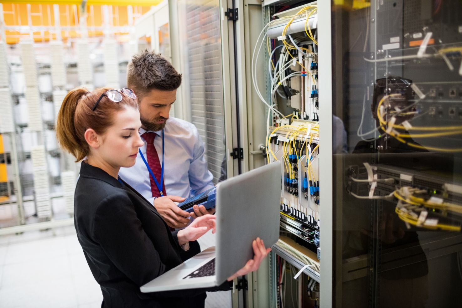 Two business people working on laptop in a maintenance room