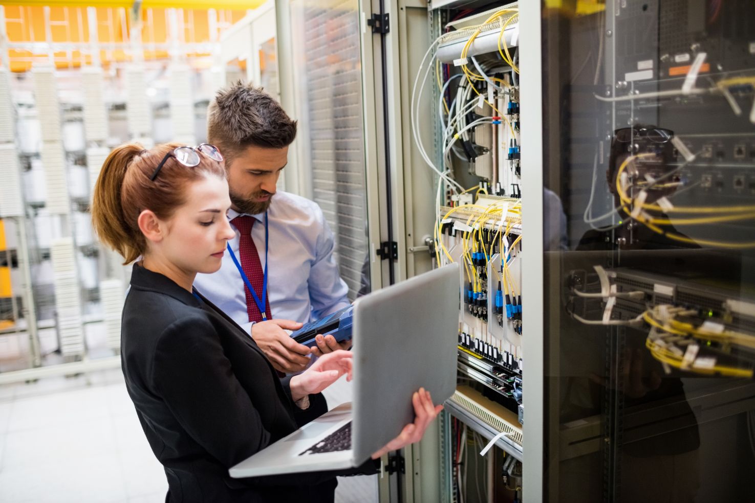 Two business people working on laptop in a maintenance room 