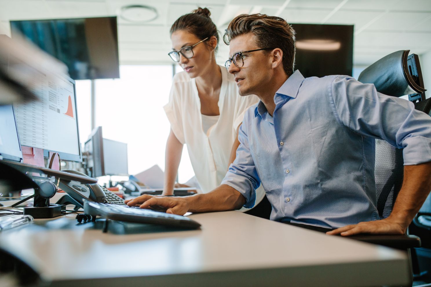 Two business people working on computer in an office