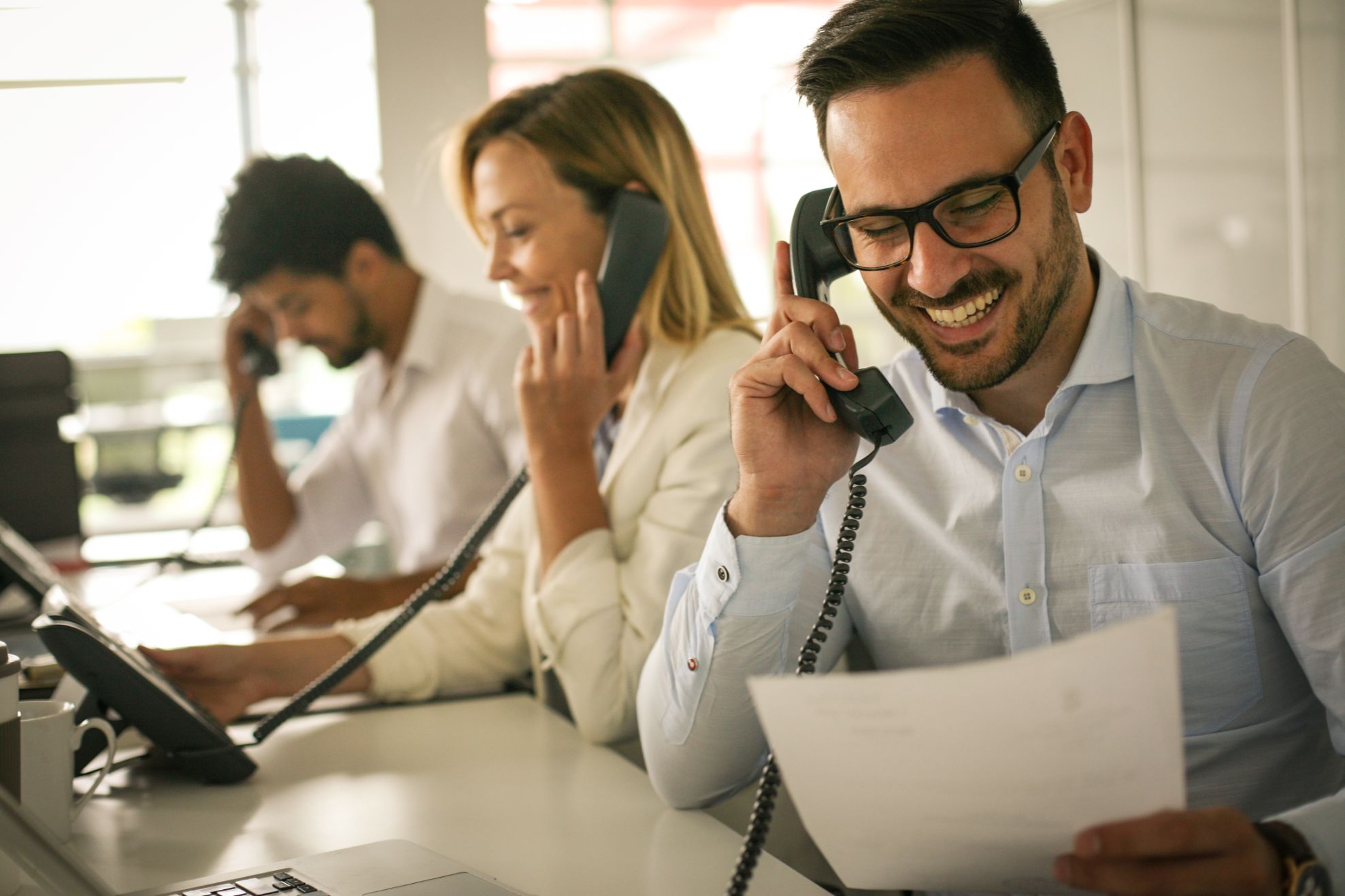 Business people talking on phones in an office