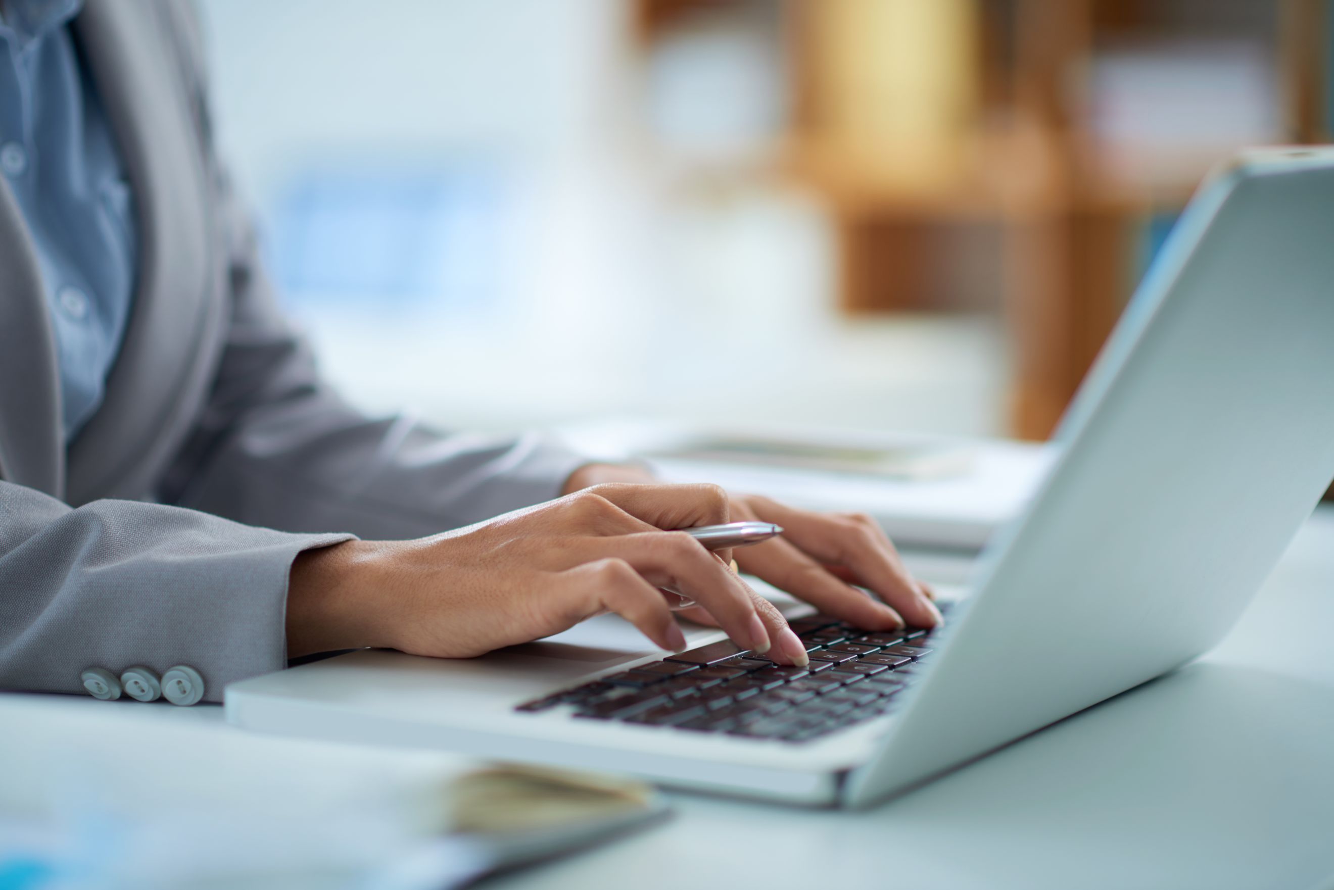 Person typing on computer at a desk 