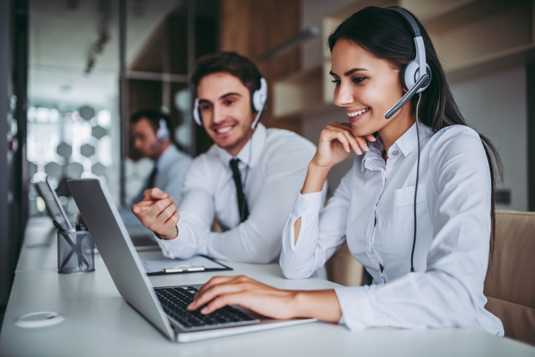 Contact center agents smiling and talking on the phone with headsets